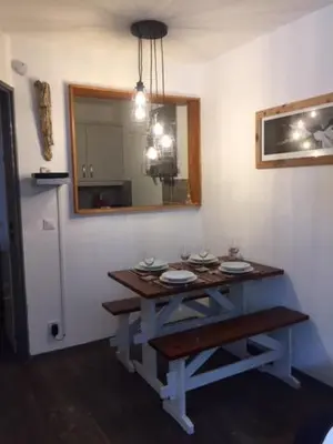 a table in a room with a mirror and a refrigerator at Chamois Blanc in Chamonix-Mont-Blanc