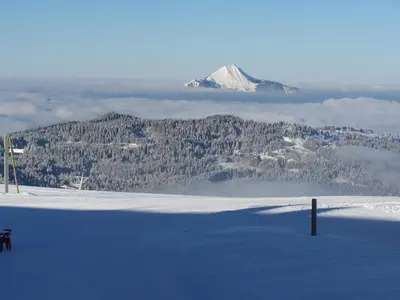 a mountain in the distance with a bench in the snow at Giffre in Samoëns