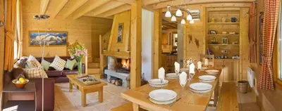 a living room with a table and a fireplace at Chalet Rimaye - Chamonix in Chamonix-Mont-Blanc