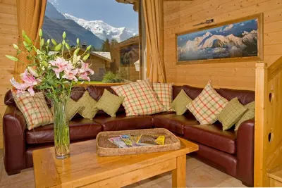 a living room with a brown leather couch and a table at Chalet Rimaye - Chamonix in Chamonix-Mont-Blanc