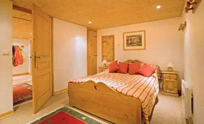 a bedroom with a bed with red pillows on it at Chalet Rimaye - Chamonix in Chamonix-Mont-Blanc