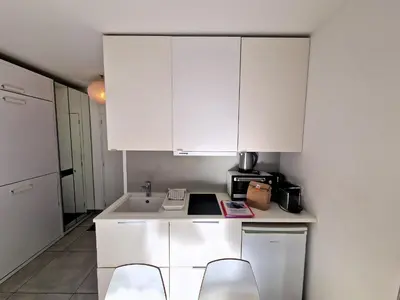 a white kitchen with white cabinets and a sink at Studio lumineux avec vue sur le massif du Mont-Blanc in Chamonix-Mont-Blanc
