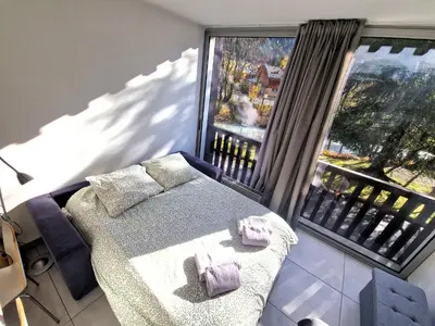 a bedroom with a bed and a large window at Studio lumineux avec vue sur le massif du Mont-Blanc in Chamonix-Mont-Blanc