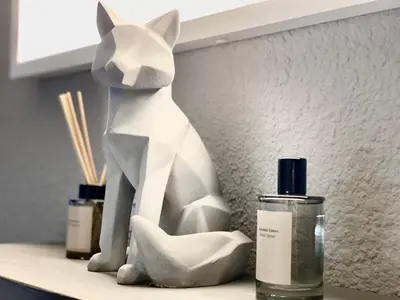 a white statue of a cat sitting on a counter with two candles at Rocky Studio Chamonix Sud in Chamonix-Mont-Blanc