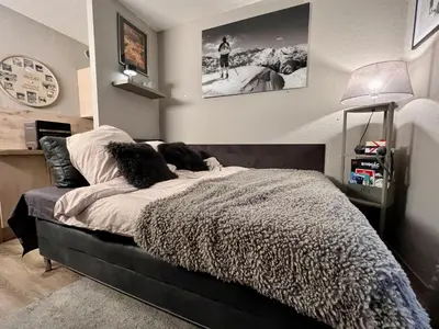a bedroom with a bed and a clock on the wall at Rocky Studio Chamonix Sud in Chamonix-Mont-Blanc