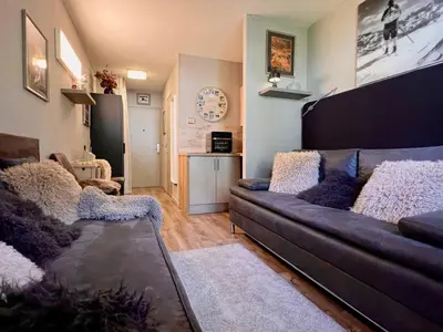 a living room with a couch and a table at Rocky Studio Chamonix Sud in Chamonix-Mont-Blanc