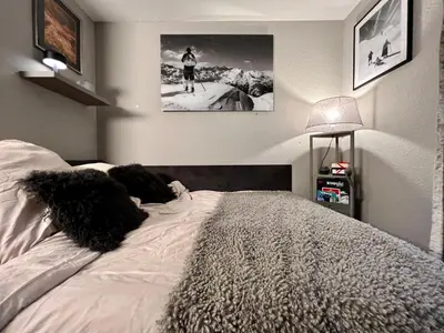 a bedroom with a bed with black pillows on it at Rocky Studio Chamonix Sud in Chamonix-Mont-Blanc