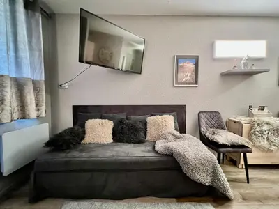 a bedroom with a bed with a television on the wall at Rocky Studio Chamonix Sud in Chamonix-Mont-Blanc