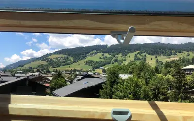 a view of a mountain through a window at Appartement du Petit Bois in Megève