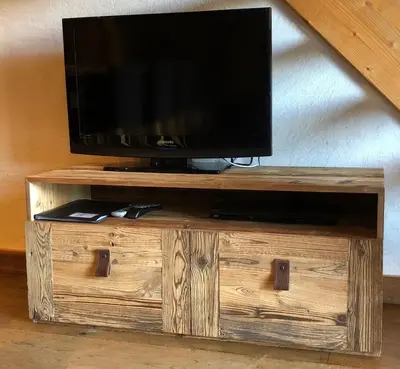 a tv sitting on top of a wooden entertainment center at Appartement du Petit Bois in Megève