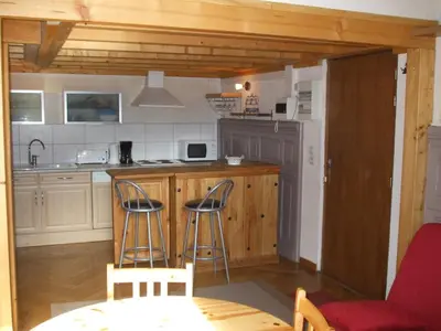 a kitchen with a counter and stools in a room at joli T3 proche centre et télécabines in Saint-Gervais-les-Bains