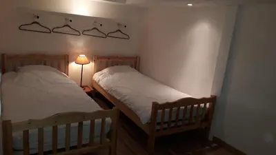 two twin beds in a room with a lamp at joli T3 proche centre et télécabines in Saint-Gervais-les-Bains