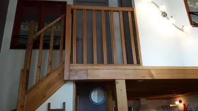 a wooden staircase in a room with a clock at joli T3 proche centre et télécabines in Saint-Gervais-les-Bains