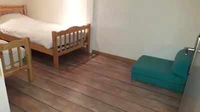 a bedroom with a bed and a blue couch at joli T3 proche centre et télécabines in Saint-Gervais-les-Bains