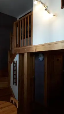 a room with a staircase with a clock on the wall at joli T3 proche centre et télécabines in Saint-Gervais-les-Bains