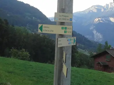 a pole with signs on it with a mountain at Cordon Balcon Du Mont Blanc in Cordon