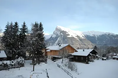 a group of buildings with snow covered mountains in the background at La Boule de Neige in Samoëns