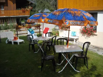 a group of tables and chairs under an umbrella at La Boule de Neige in Samoëns