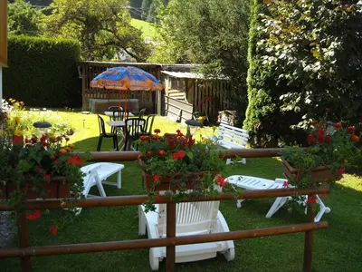 a garden with tables and chairs and flowers in the grass at La Boule de Neige in Samoëns