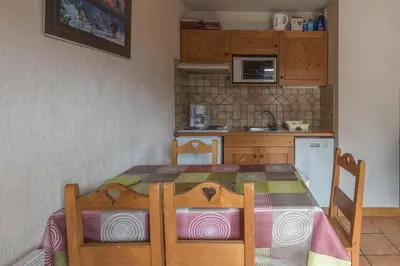 a kitchen with a table and a table and chairs at appartement T2 LES HOUCHES Pied des Pistes in Les Houches