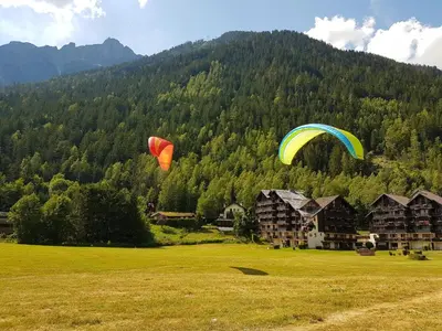 two kites flying over a field in front of a mountain at Le Sapi 1E Balcon panoramique Aiguilles Rouges avec parking gratuit in Chamonix-Mont-Blanc