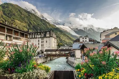 a river in a town with mountains in the background at Le Sapi 1E Balcon panoramique Aiguilles Rouges avec parking gratuit in Chamonix-Mont-Blanc
