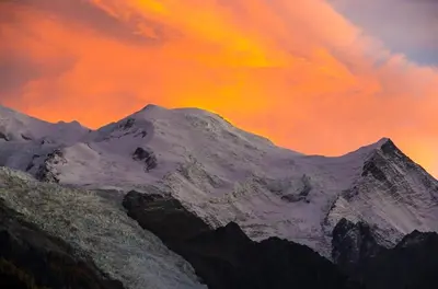 a mountain covered in snow under a cloudy sky at Le Sapi 1E Balcon panoramique Aiguilles Rouges avec parking gratuit in Chamonix-Mont-Blanc