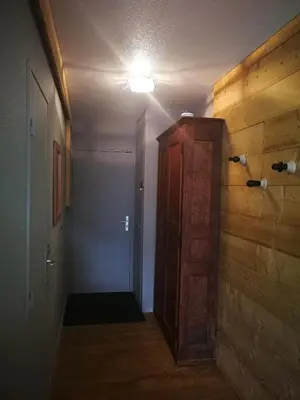 a hallway with a door and a room with wooden walls at La Cabane in Chamonix-Mont-Blanc