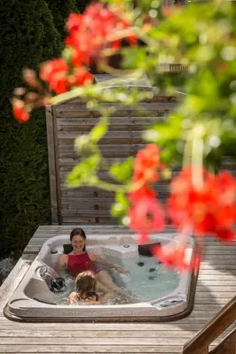 a woman in a jacuzzi with a dog in a pool at Les Rives d'Argentière in Chamonix-Mont-Blanc