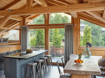 a kitchen with a large window and a table with chairs at Les Rives d'Argentière in Chamonix-Mont-Blanc
