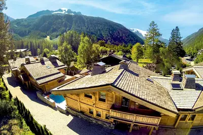 an aerial view of a house with mountains in the background at Les Rives d'Argentière in Chamonix-Mont-Blanc