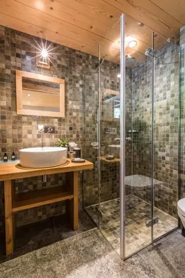 a bathroom with a sink and a glass shower at Les Rives d'Argentière in Chamonix-Mont-Blanc