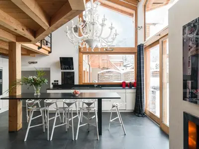a kitchen with a dining room table and a chandelier at Les Rives d'Argentière in Chamonix-Mont-Blanc