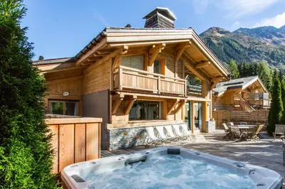 a large wooden house with a hot tub in the yard at Les Rives d'Argentière in Chamonix-Mont-Blanc