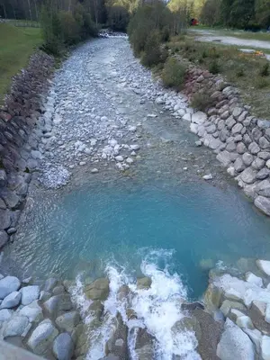 a river with rocks and blue water at Appartement avec Terrasse in Chamonix-Mont-Blanc