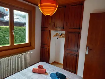 a bedroom with a bed and a window and a light at Appartement avec Terrasse in Chamonix-Mont-Blanc