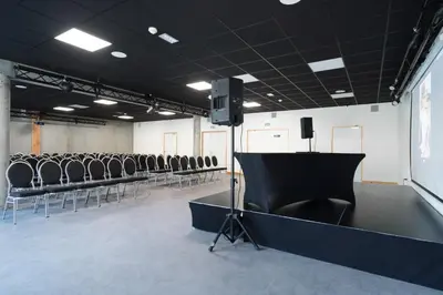 a room with a row of chairs and a stage at Village Vacances le Bérouze in Samoëns