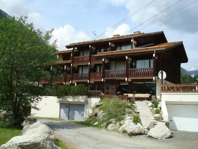 a large wooden building with a road in front of it at Residence La Verte 24- Aux Pieds des pistes! in Chamonix-Mont-Blanc
