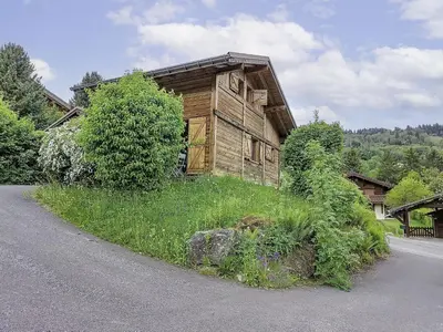 a house on the side of a road with mountains in the background at Holiday Home Les Farfadets by Interhome in Saint-Gervais-les-Bains