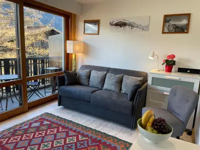 a living room with a couch and a table at Apartment Le Pied du Brevent - Walk to Ski Lift, Chamonix Getaway in Chamonix-Mont-Blanc