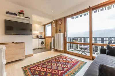 a living room with a couch and a large window at Apartment Le Pied du Brevent - Walk to Ski Lift, Chamonix Getaway in Chamonix-Mont-Blanc