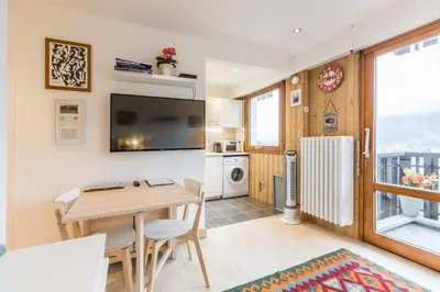 a kitchen and dining room with a table and a refrigerator at Apartment Le Pied du Brevent - Walk to Ski Lift, Chamonix Getaway in Chamonix-Mont-Blanc