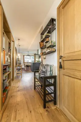 a hallway with a wooden door and a chair in a room at Appartement Native in Chamonix-Mont-Blanc