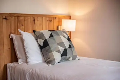 a bed with a black and white pillow on it at BIOLAY 2 - Alpes Travel - Central Chamonix - Sleeps 4-6 in Chamonix-Mont-Blanc