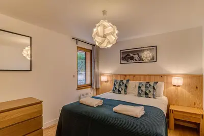 a bedroom with a bed and a chandelier at BIOLAY 2 - Alpes Travel - Central Chamonix - Sleeps 4-6 in Chamonix-Mont-Blanc