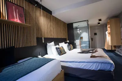 a hotel room with two beds and a mirror at La Folie Douce Hotels Chamonix in Chamonix-Mont-Blanc