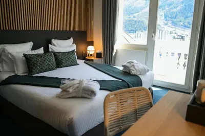 two beds in a hotel room with towels on them at La Folie Douce Hotels Chamonix in Chamonix-Mont-Blanc