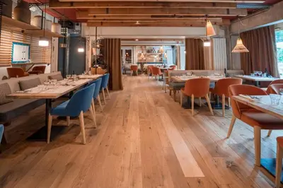 a restaurant with wooden floors and tables and chairs at La Folie Douce Hotels Chamonix in Chamonix-Mont-Blanc