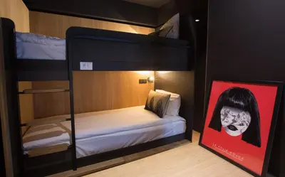 a room with a bunk bed with a poster of a girl at La Folie Douce Hotels Chamonix in Chamonix-Mont-Blanc