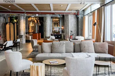 a living room with a couch and tables and chairs at La Folie Douce Hotels Chamonix in Chamonix-Mont-Blanc
